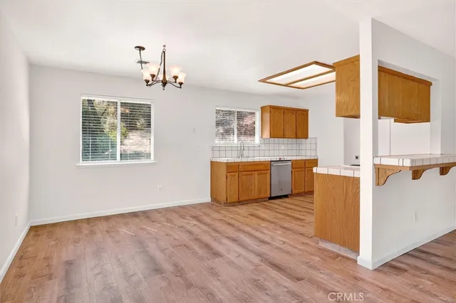 a view of a kitchen with wooden floor and electronic appliances