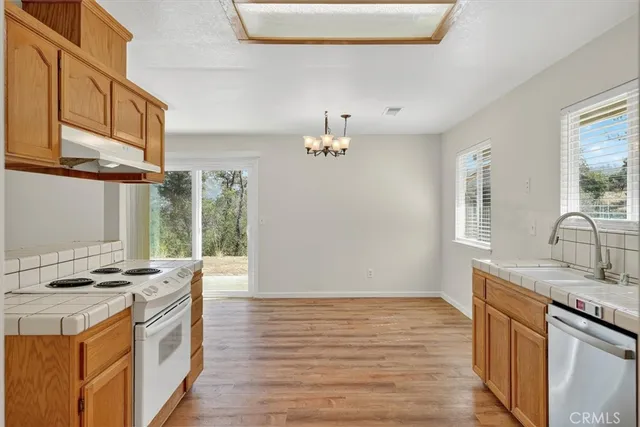 a kitchen with stainless steel appliances granite countertop a sink stove and wooden floor
