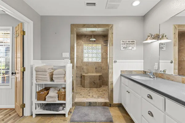 a en suite bathroom with a shower sink and mirror
