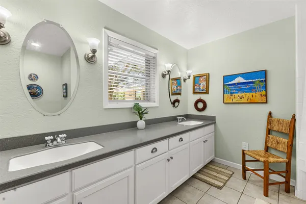 a bathroom with a granite countertop double vanity sink and a mirror