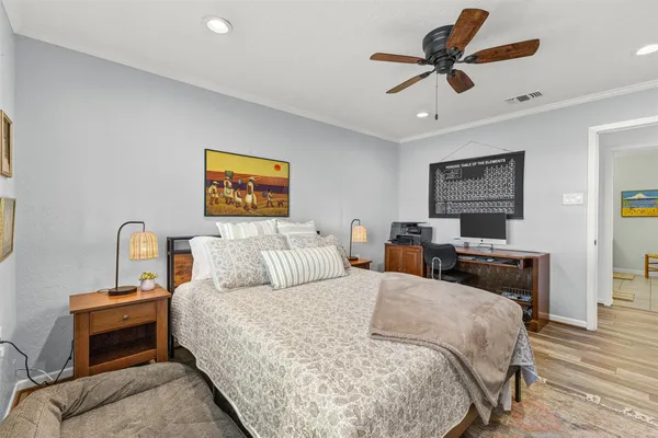 a bed room with a bed a couch and a ceiling fan