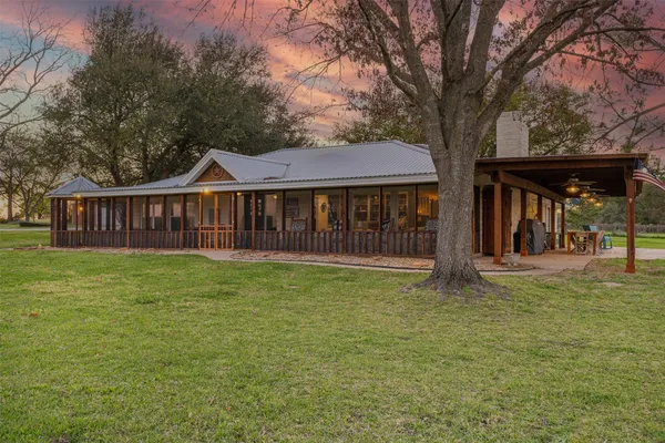 a view of a house with a yard and a tree