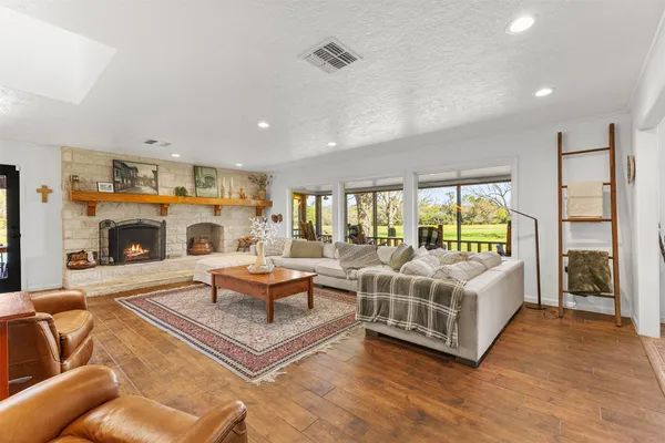 a living room with furniture large window and a fireplace