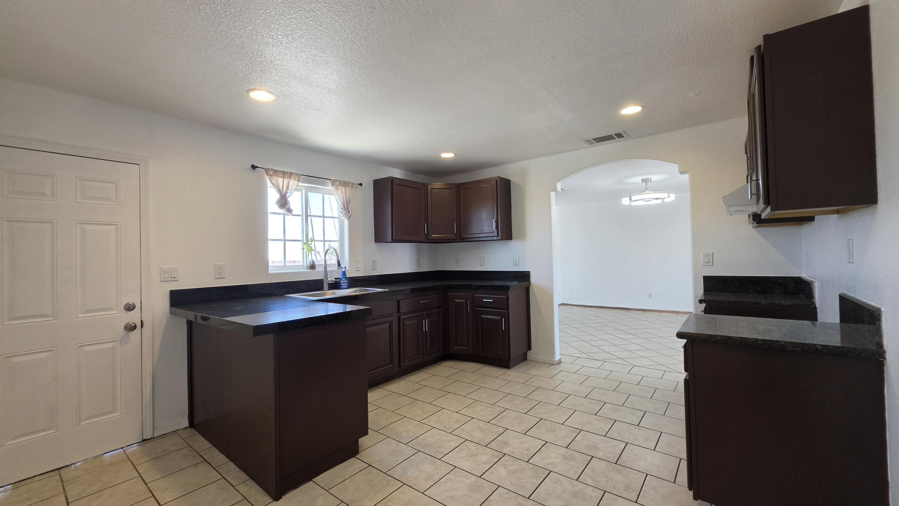 2778 Calhoun Street Thermal, CA 92274 - Photo 11 of 23 a kitchen with granite countertop a sink and a stove top oven