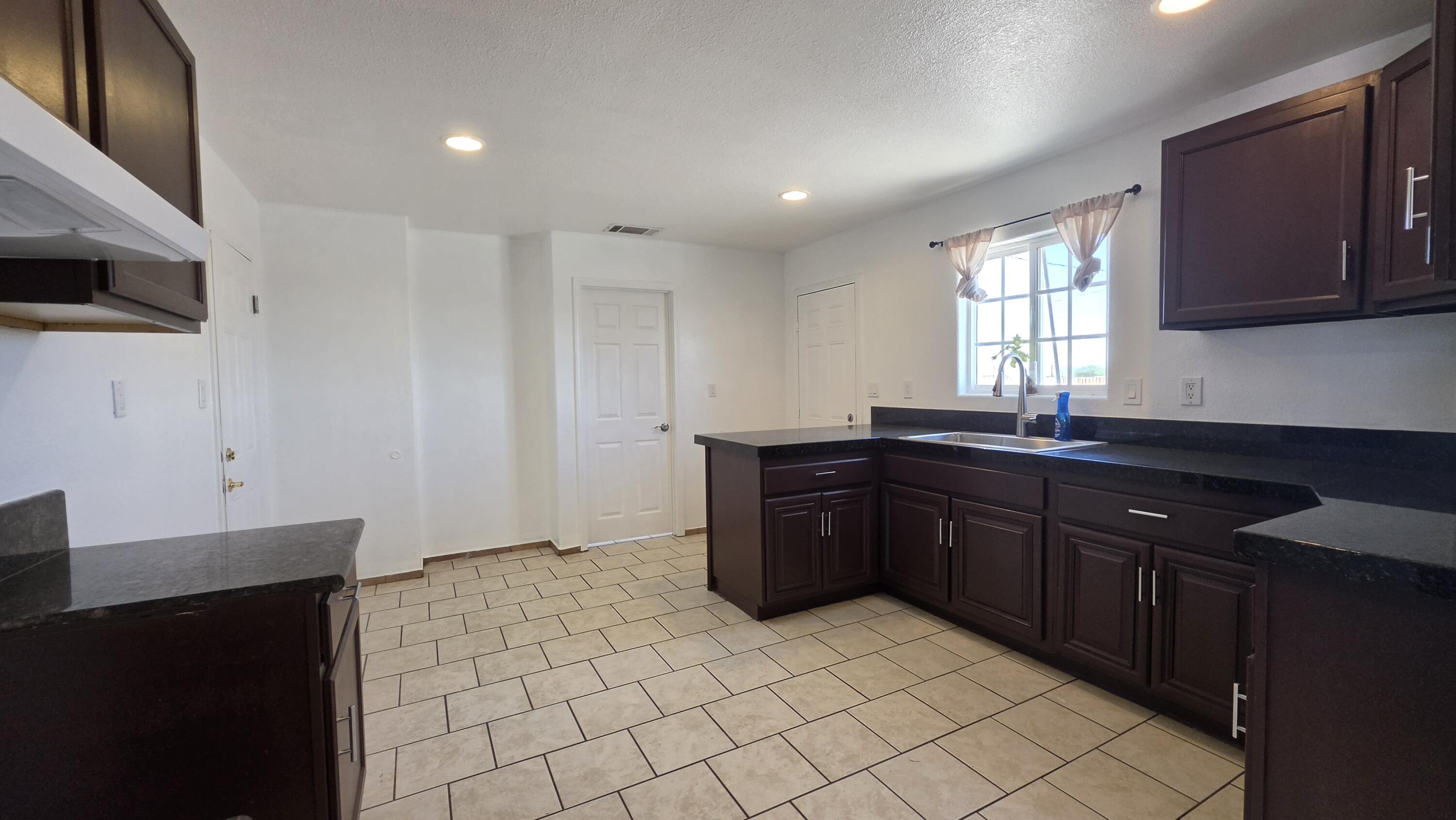 2778 Calhoun Street Thermal, CA 92274 - Photo 10 of 23 a kitchen with a sink and a stove top oven with wooden floor