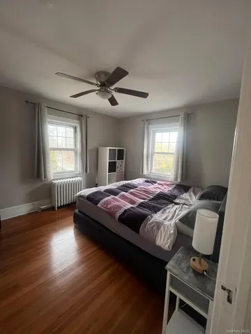 a spacious bedroom with a bed and wooden floor
