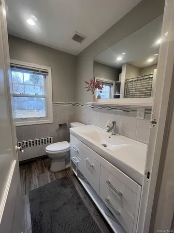 a spacious bathroom with a toilet a sink and a large mirror