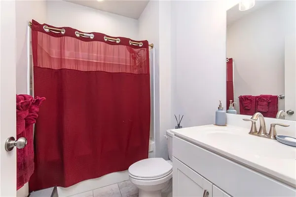 a bathroom with a sink a toilet and shower curtain