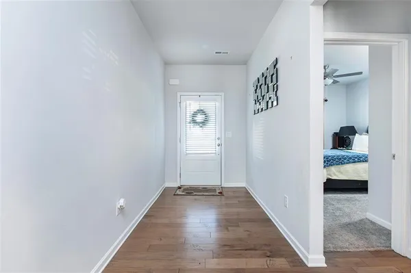 a view of a hallway with wooden floor and closet
