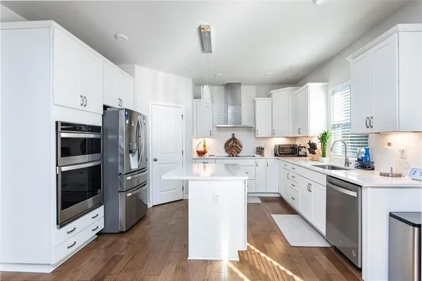 a kitchen with white cabinets and stainless steel appliances