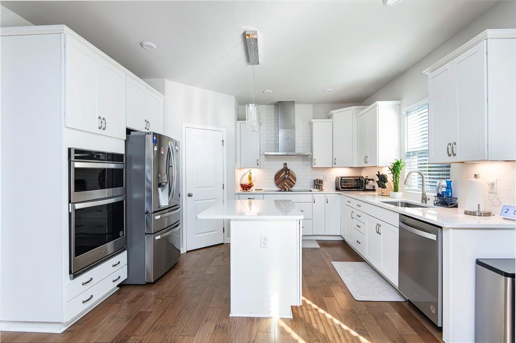 280 Mackenzie Court Covington, GA 30016 - Photo 6 of 24 a kitchen with white cabinets and stainless steel appliances