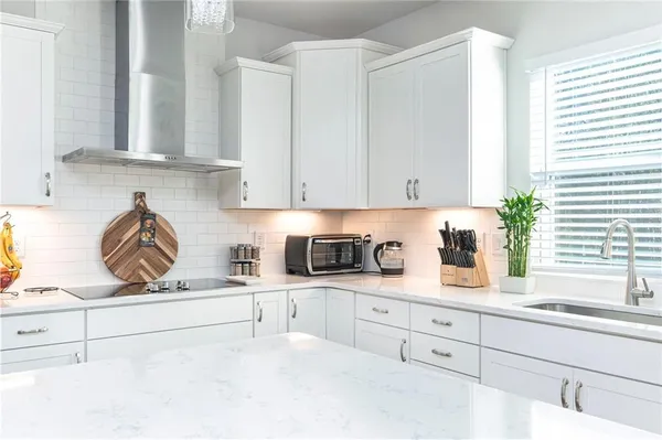 a kitchen with granite countertop white cabinets and white appliances