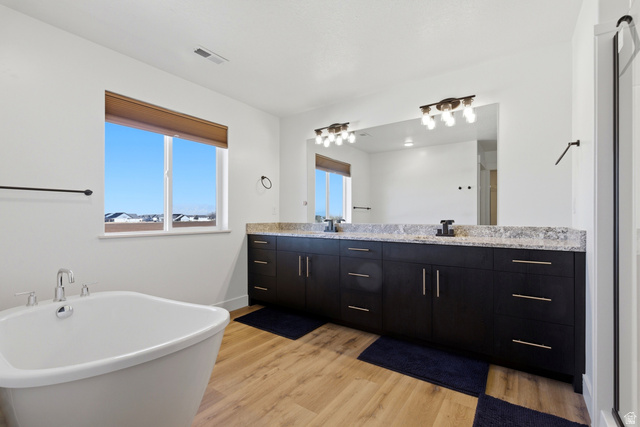 3902 West 825 North West Point, UT 84015 - Photo 17 of 49 Full bathroom featuring double vanity, light wood-type flooring, and a freestanding bath