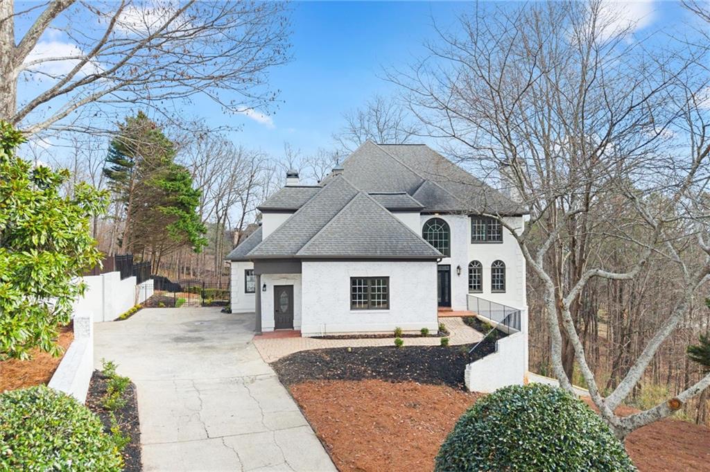 a front view of a house with garden and chairs