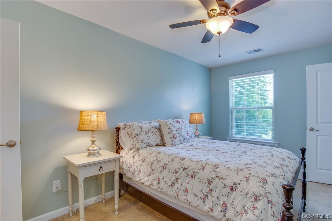 5841 Riverside Trail Richmond, VA 23225 - Photo 21 of 28 a bedroom with a large bed and a chandelier