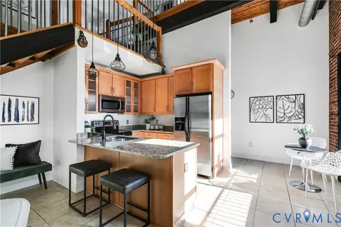 a kitchen with stainless steel appliances granite countertop a sink refrigerator and cabinets