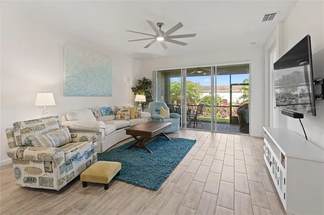 a living room with furniture and a large window with wooden floor