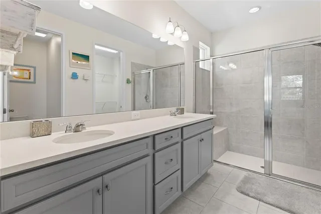 a bathroom with a double vanity sink mirror and shower