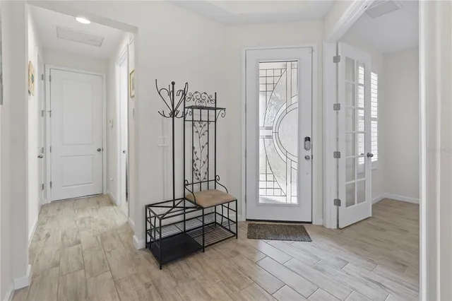a view of a hallway with entryway wooden floor and front door