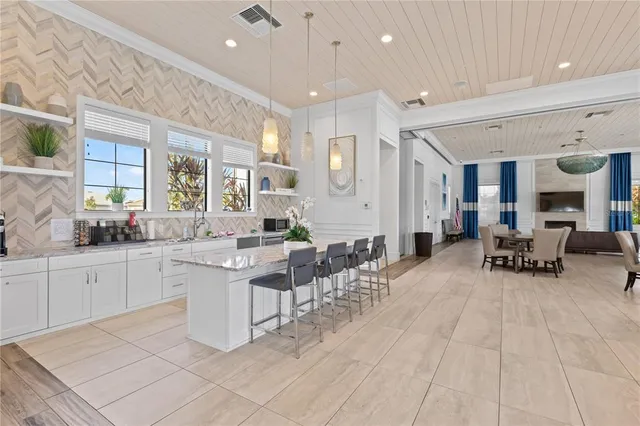 a large white kitchen with lots of table and chairs