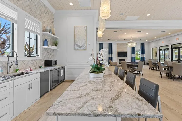 a large white kitchen with cabinets a sink and appliances