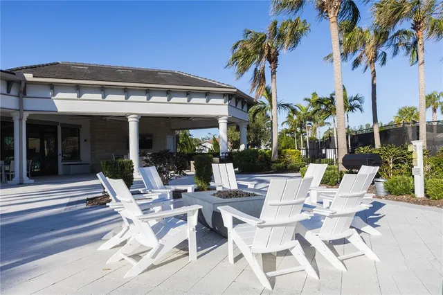 a view of a patio with table and chairs potted plants and palm tree