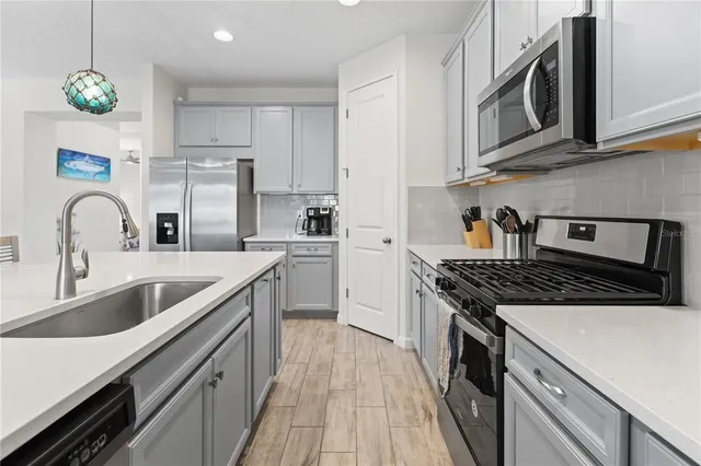 a kitchen with stainless steel appliances granite countertop a sink stove and refrigerator