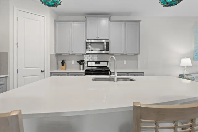 a close view of a stove top oven a sink and dishwasher with white cabinets