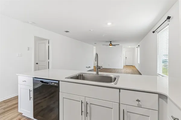 a kitchen with a refrigerator a stove top oven a sink and dishwasher with wooden floor