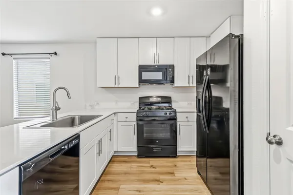 a view of kitchen with wooden floor and electronic appliances