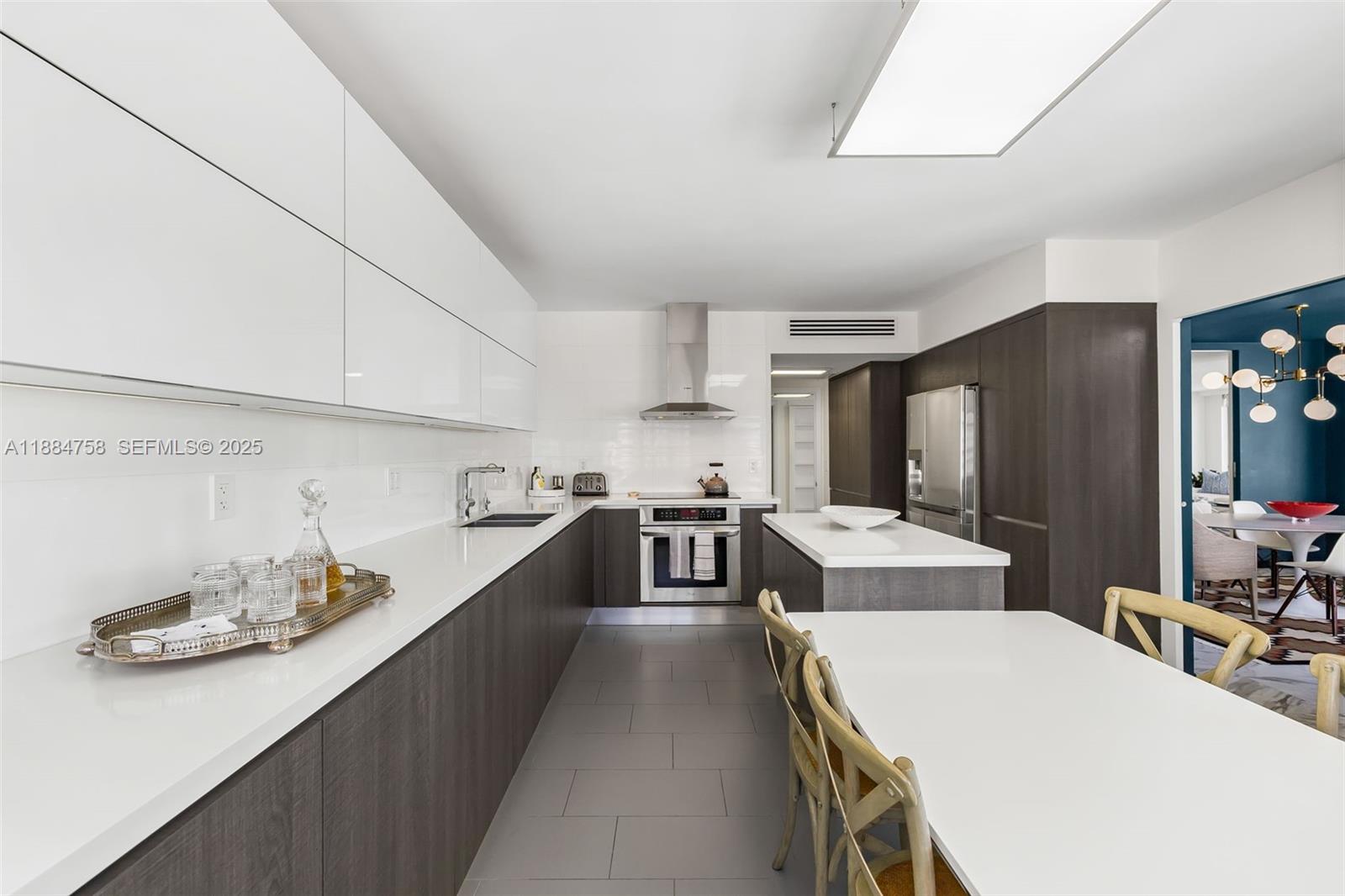 5660 Collins Avenue, Unit 8D Miami Beach, FL 33140 - Photo 12 of 41 a large kitchen with a large counter top appliances and cabinets