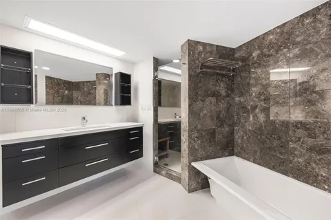 a bathroom with a tub a sink and mirror