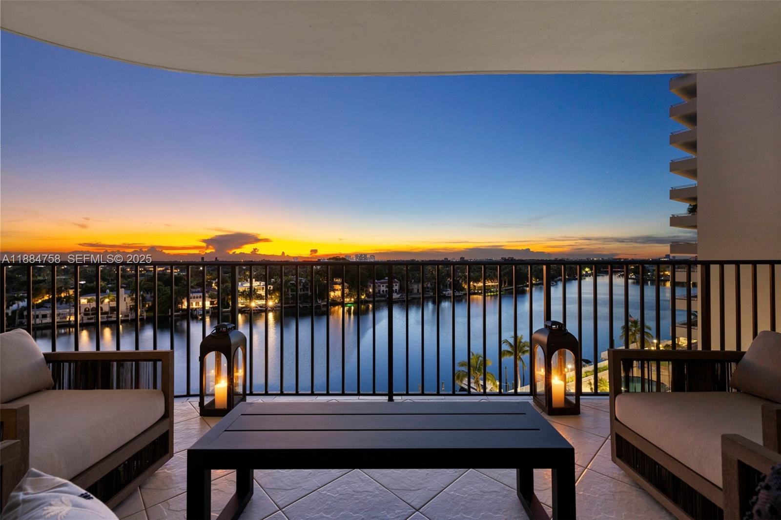 5660 Collins Avenue, Unit 8D Miami Beach, FL 33140 - Photo 31 of 41 a balcony with wooden floor table and chairs