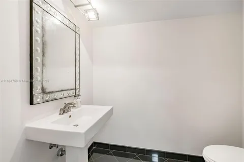 a bathroom with a sink toilet and mirror
