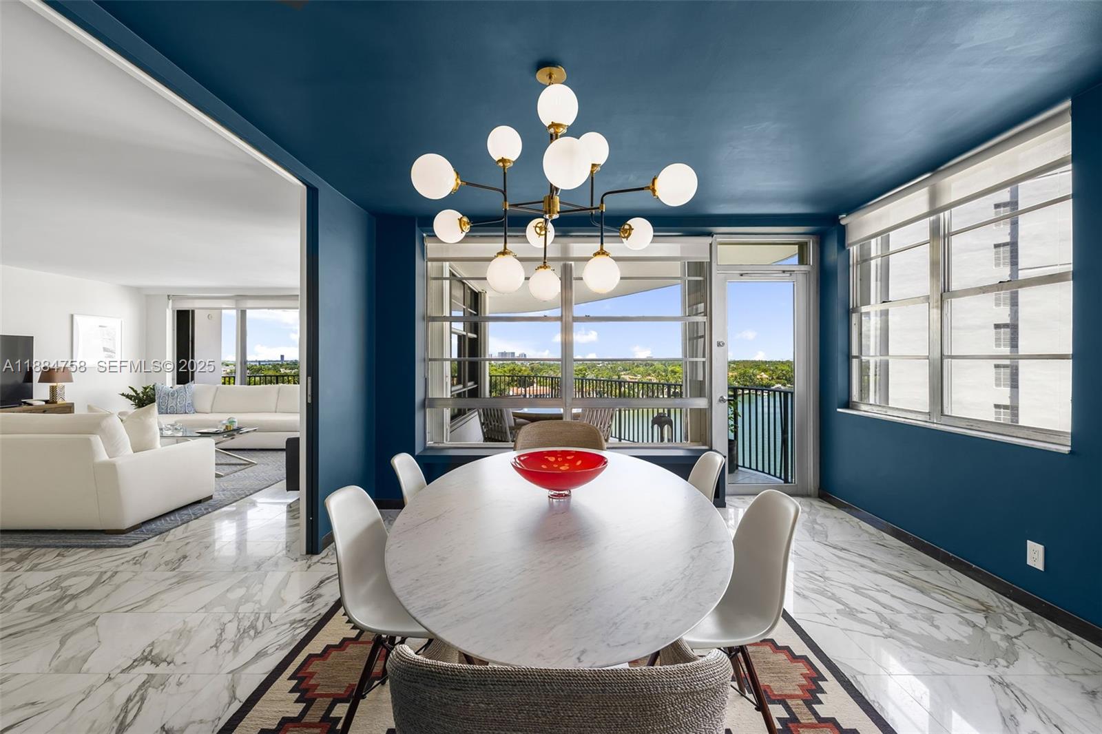 5660 Collins Avenue, Unit 8D Miami Beach, FL 33140 - Photo 8 of 41 a view of a dining room with furniture wooden floor and chandelier