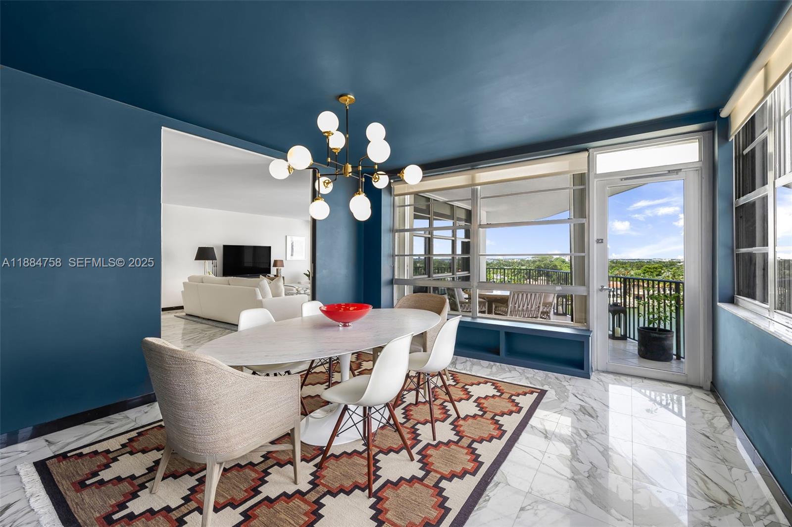 5660 Collins Avenue, Unit 8D Miami Beach, FL 33140 - Photo 9 of 41 a view of a dining room with furniture wooden floor and chandelier