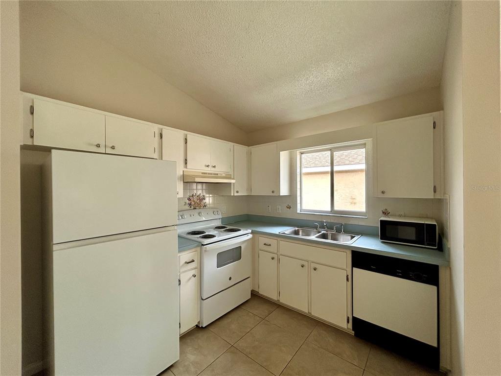 1907 Northwest 50th Circle Ocala, FL 34482 - Photo 7 of 25 a kitchen with white cabinets sink and white appliances