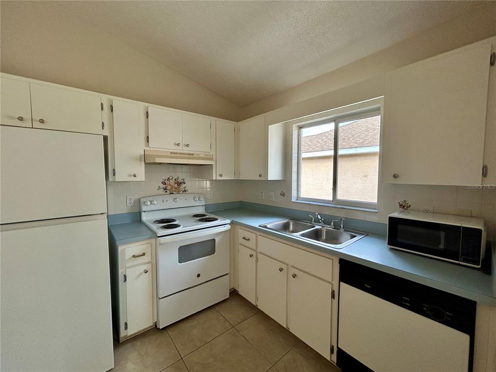 1907 Northwest 50th Circle Ocala, FL 34482 - Photo 9 of 25 a kitchen with cabinets appliances a sink and a window