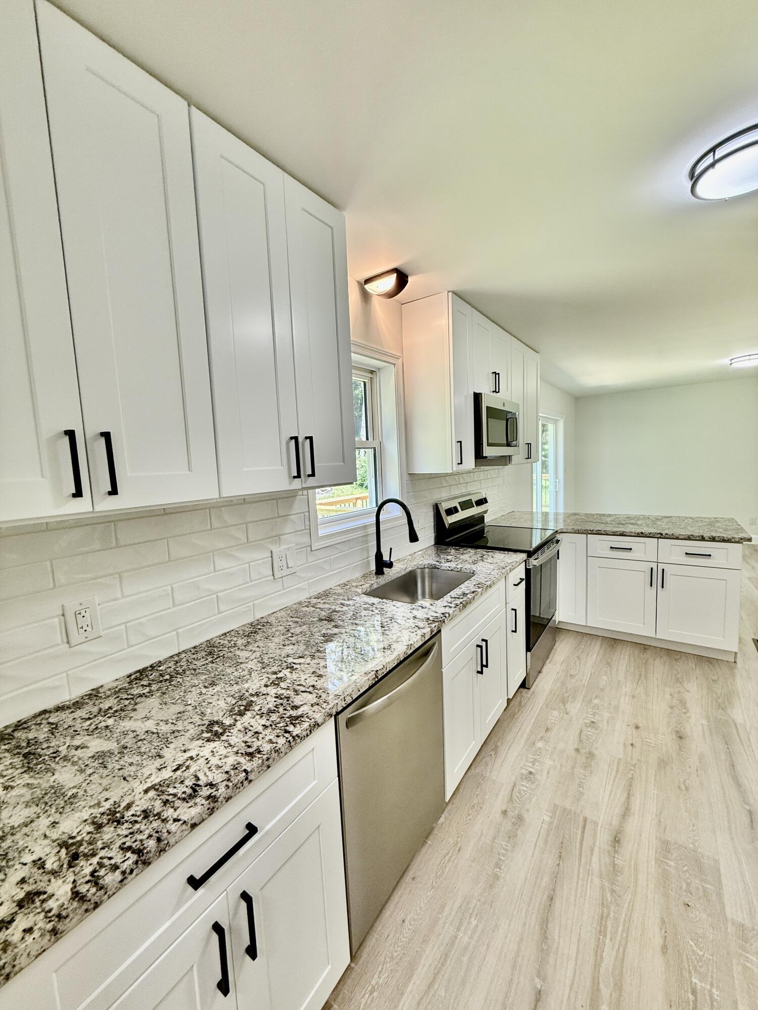 459 Pocono Boulevard Bushkill, PA 18324 - Photo 6 of 62 a large white kitchen with granite countertop a sink dishwasher stove and cabinets