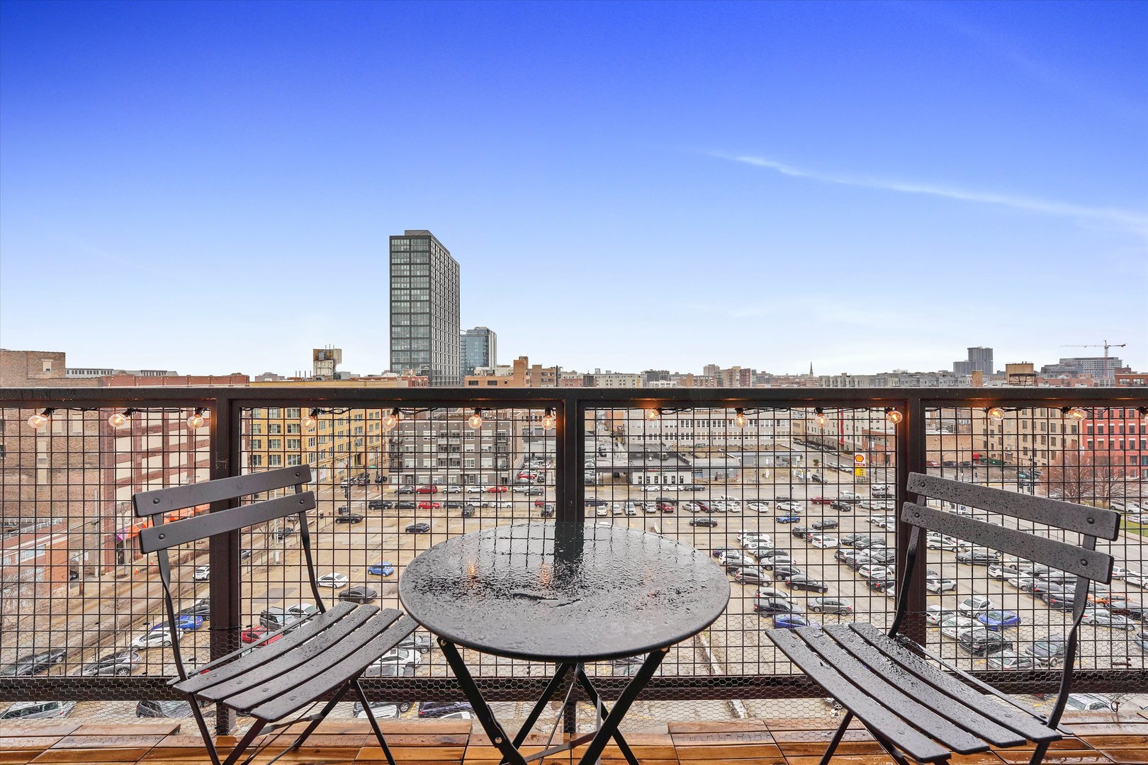 321 South Sangamon Street, Unit 902 Chicago, IL 60607 - Photo 5 of 18 a balcony with table and chairs and wooden floor