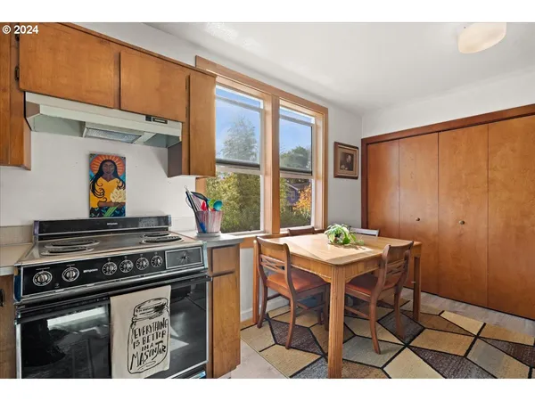 a kitchen with a stove a refrigerator and a dining table