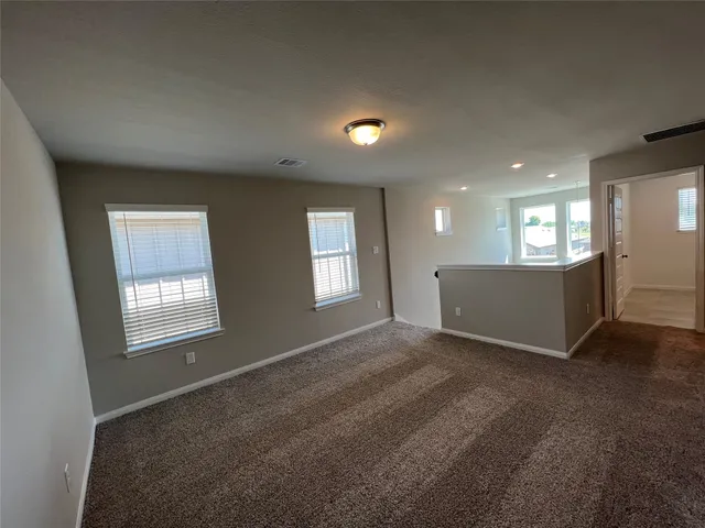 a view of an empty room with a window and fireplace