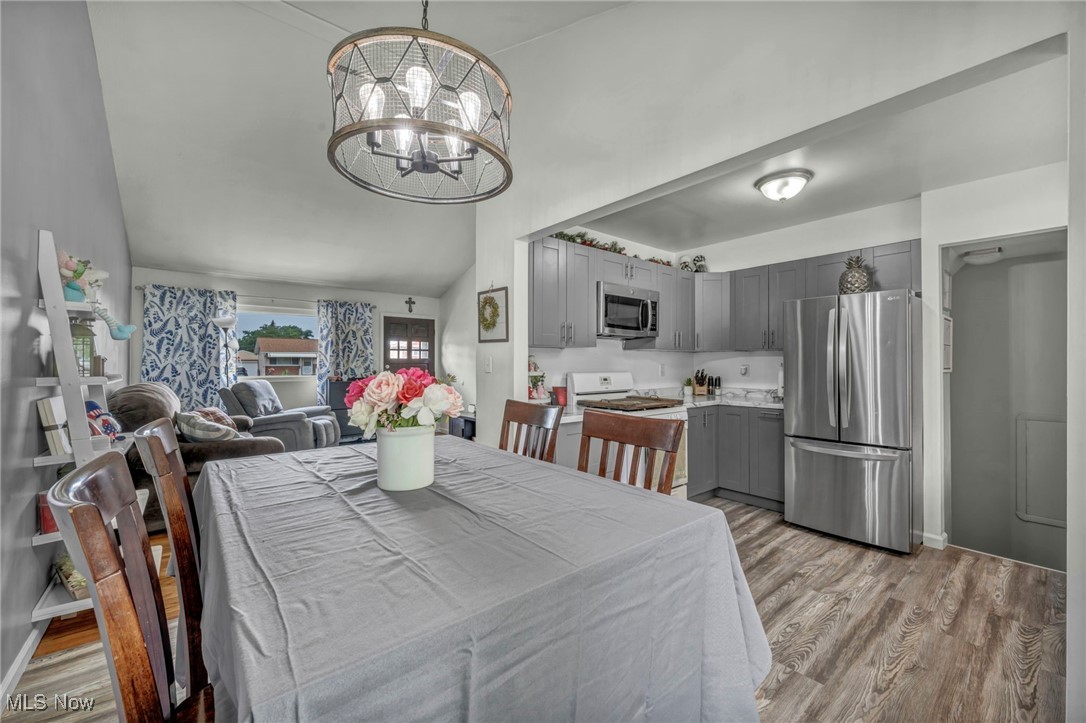 15025 Holland Road Brook Park, OH 44142 - Photo 4 of 12 Dining area featuring a chandelier, light wood-style flooring, and high vaulted ceiling