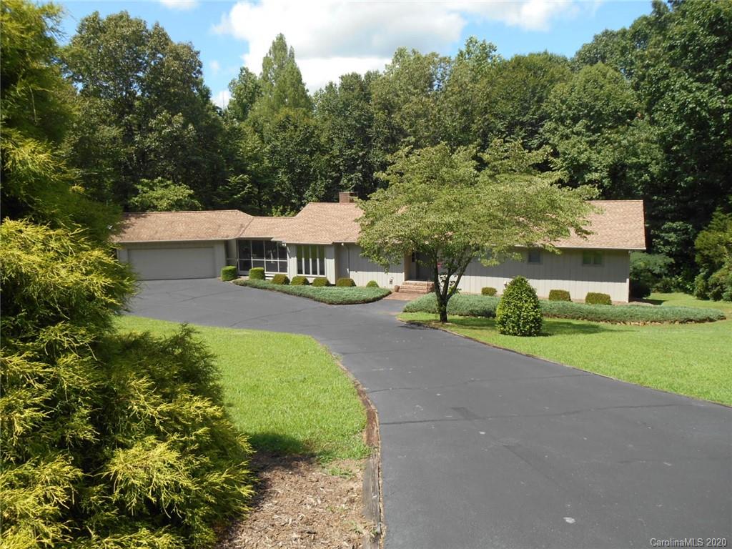 a view of a house with a yard and sitting area