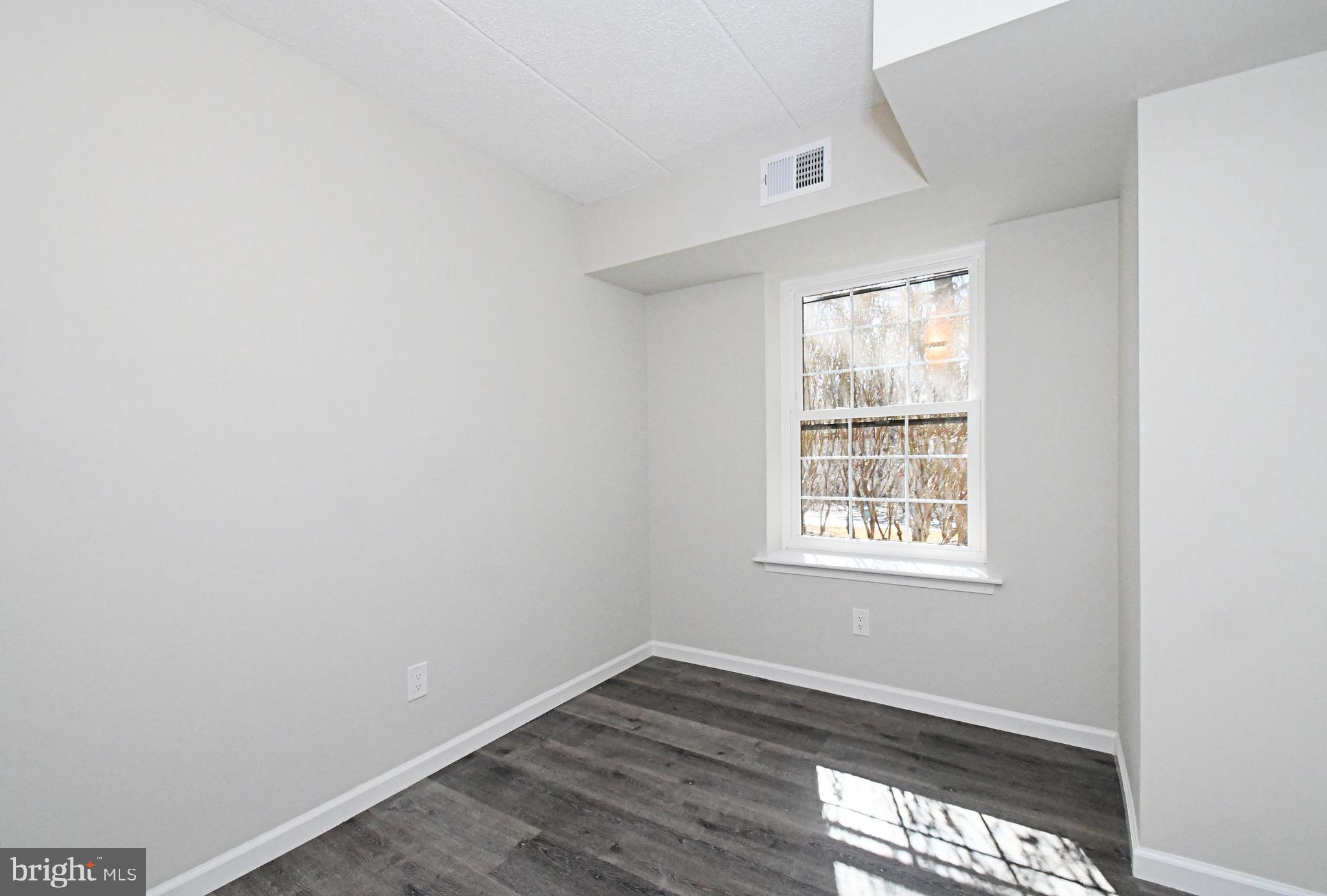 613 Washington Place, Unit 13 Chesterbrook, PA 19087 - Photo 11 of 64 an empty room with wooden floor and windows