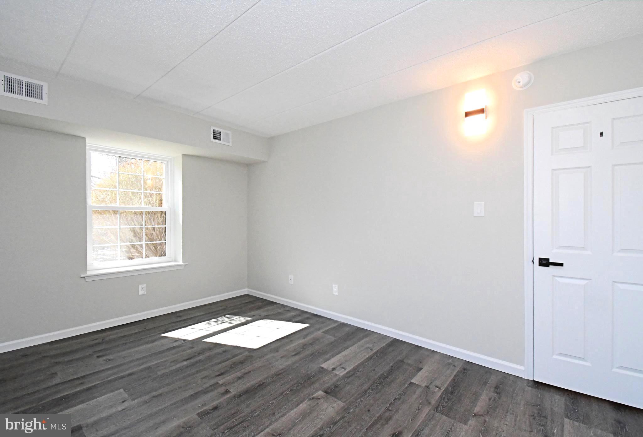 613 Washington Place, Unit 13 Chesterbrook, PA 19087 - Photo 14 of 64 an empty room with wooden floor and windows