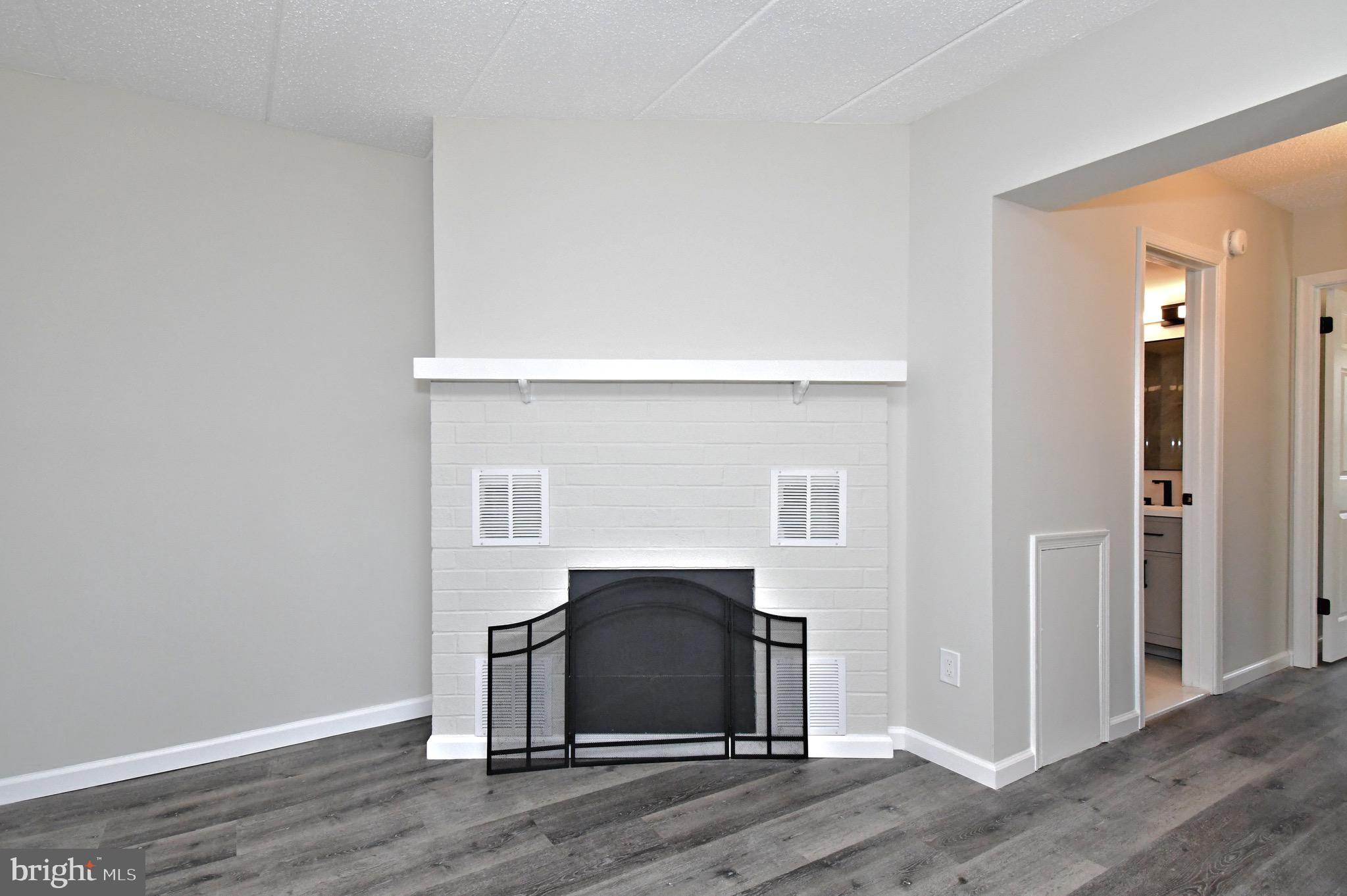613 Washington Place, Unit 13 Chesterbrook, PA 19087 - Photo 20 of 64 a living room with a fireplace and wooden floor