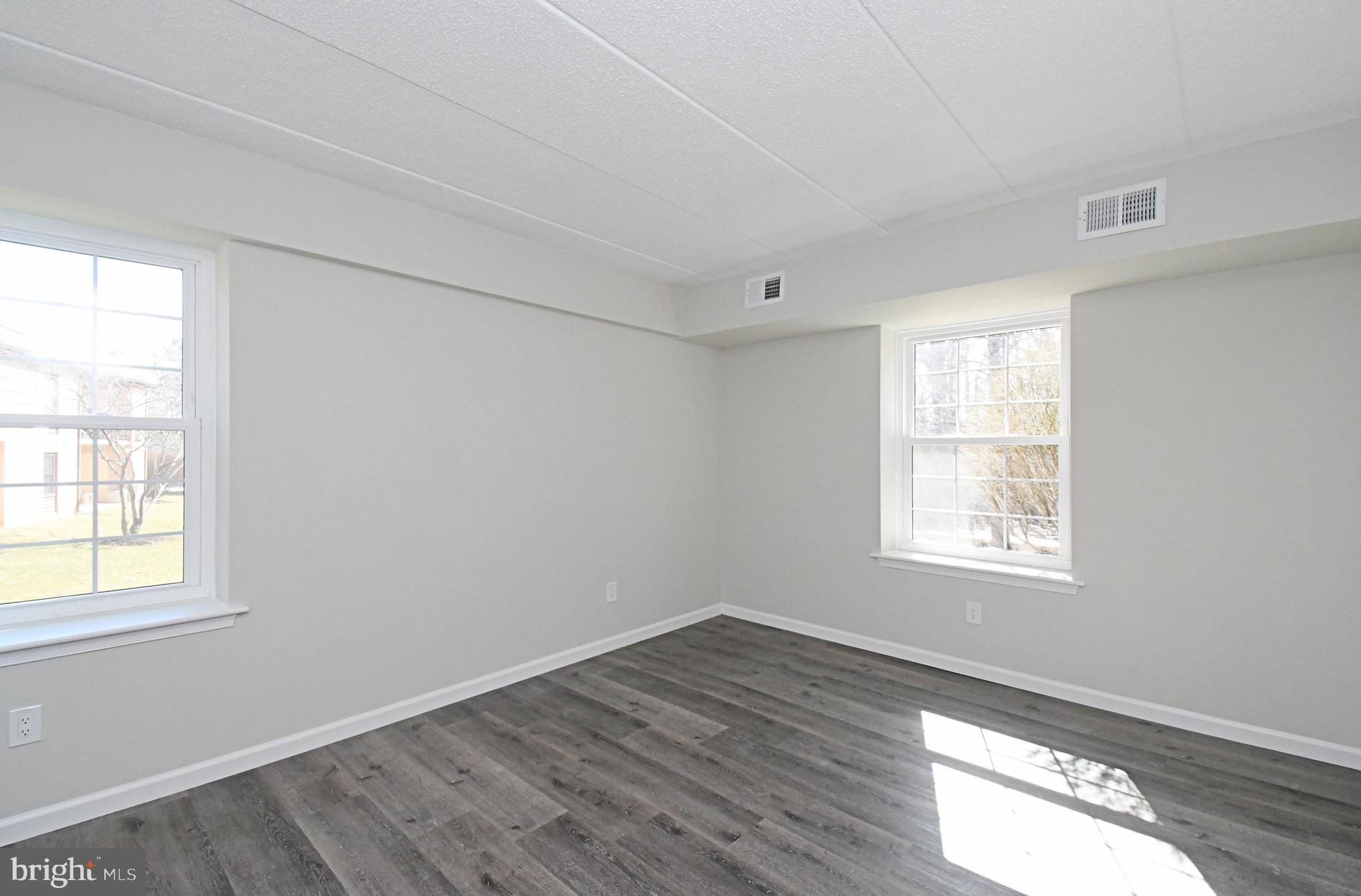 613 Washington Place, Unit 13 Chesterbrook, PA 19087 - Photo 21 of 64 an empty room with wooden floor and windows