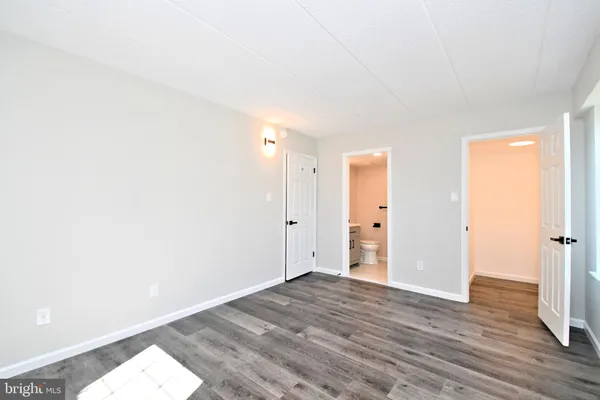 a view of empty room with wooden floor and fireplace