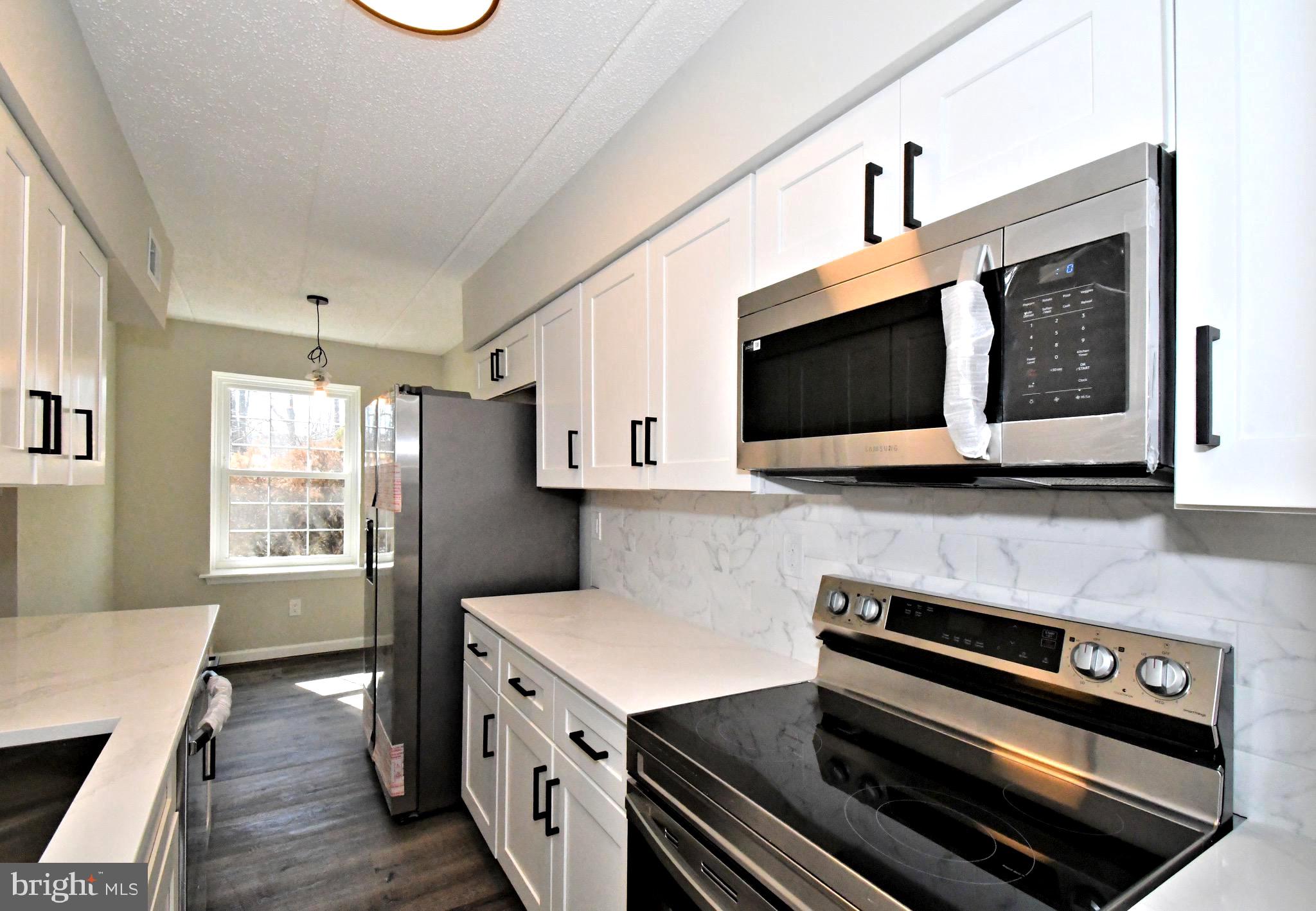 613 Washington Place, Unit 13 Chesterbrook, PA 19087 - Photo 29 of 64 a kitchen with stainless steel appliances a stove microwave and sink
